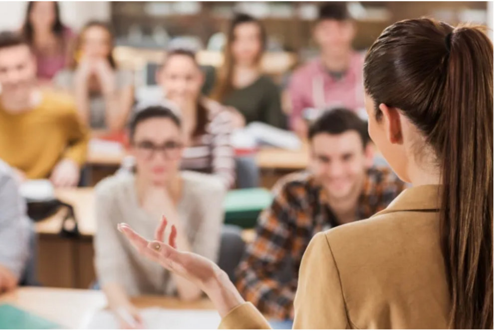 Eine Frau spricht vor Studierenden.