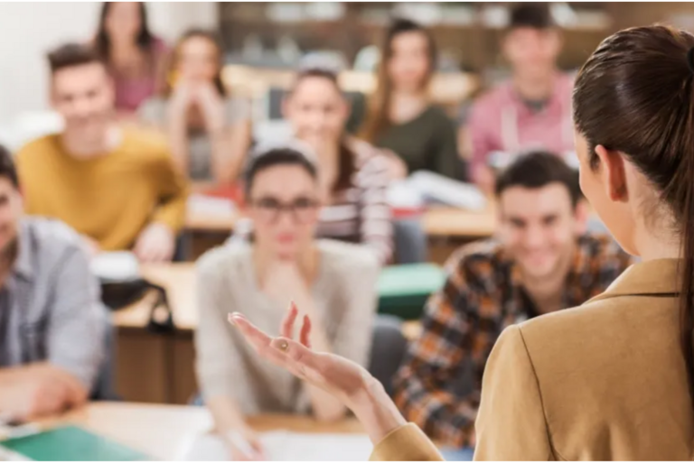 Eine Frau spricht vor Studierenden.