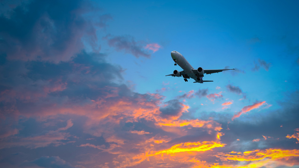 Ein Flugzeug steigt in der D&auml;mmerung auf