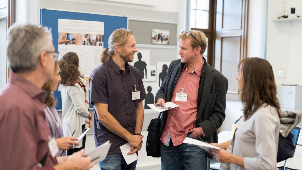 Ein Professor der Universit&auml;t Passau unterh&auml;lt sich interessiert mit einer Lehrperson.