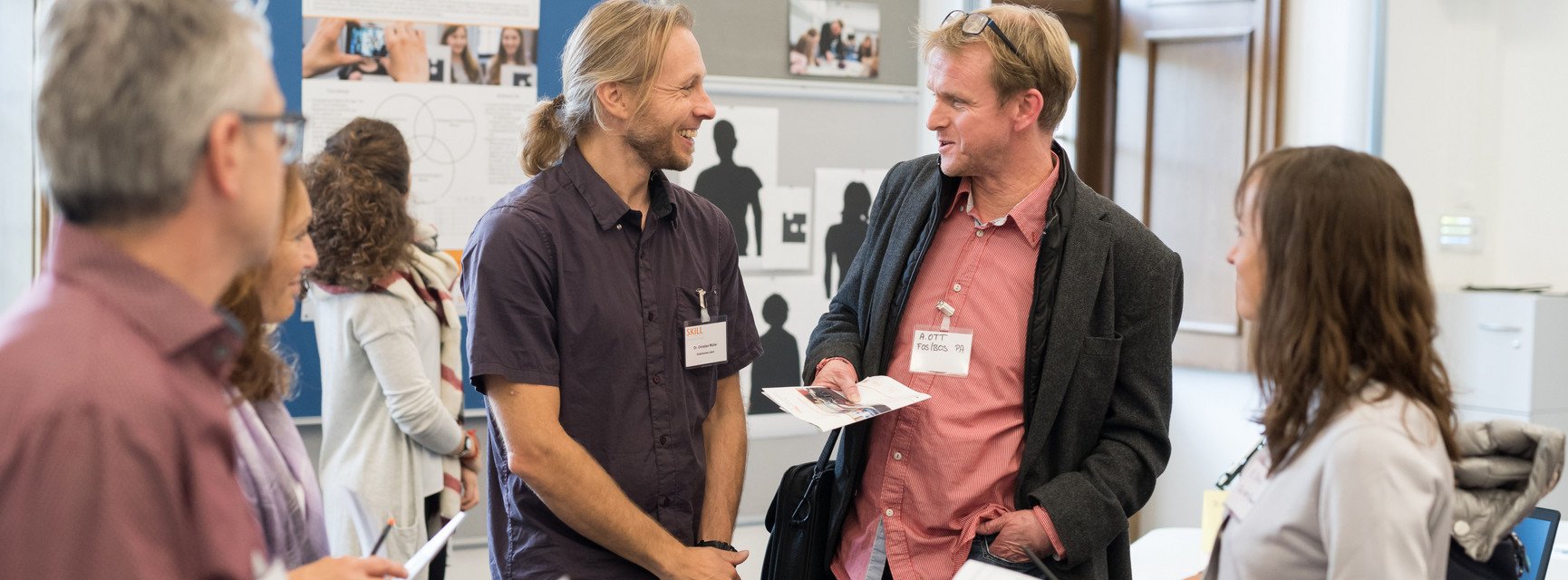Ein Professor der Universit&auml;t Passau unterh&auml;lt sich interessiert mit einer Lehrperson.
