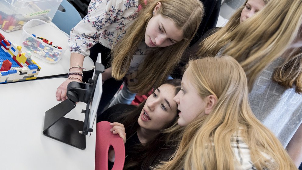 Ein paar Sch&uuml;lerinnen bei einer F&uuml;hrung im DiLab der Universit&auml;t Passau. Sie arbeiten mit einem Tablet und sehen alle gespannt auf den Bildschirm.